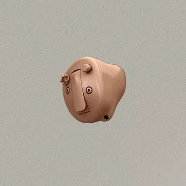 Tan canal style hearing aid.
