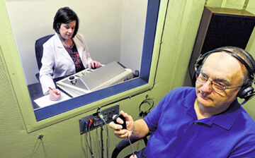 Dr. Lisa B. Fell conducting a hearing test for a patient at Audiology Experts in Arlington, TX.