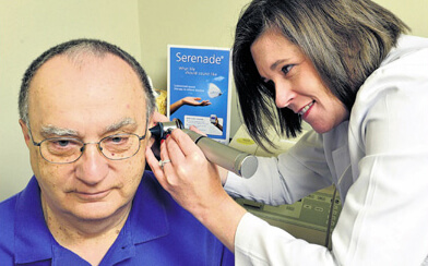 Dr. Lisa B. Fell looking at in a patient's ear at Audiology Experts in Arlington, TX.